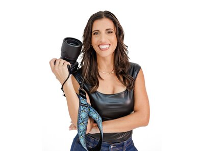 Jo, founder of Branding by Jo smiling with her arms crossed for a lifestyle headshot at a studio in Orlando.