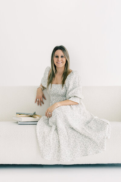 Portrait of Katie Petrick, Charlotte newborn photographer, standing in studio and smiling, representing full-service motherhood photography