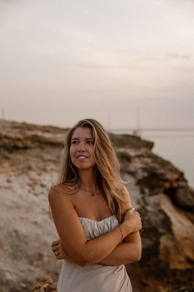 Woman posing on a rocky beach on Ibiza