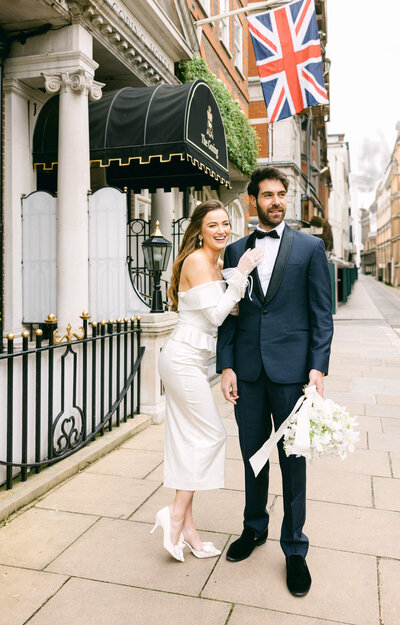 a wedding photo of a couple smiling and holding each other on the streets of London in the Uk