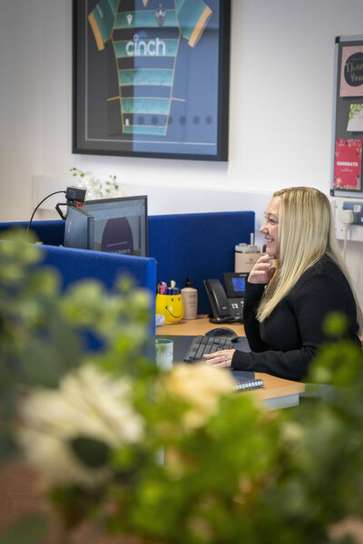 lady on a phone call whilst working at her desk