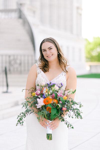 bride holding colorful bouquet at missouri state capital building