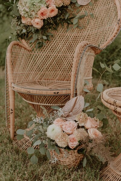 Boho wedding decor, flowers, and trendy wicker chair. Feels warm and chic.