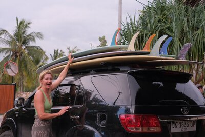 Woman packing car with surfboards at Santai Retreats - longboarding surf surf retreat in Indonesia