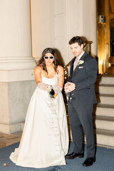 Bride and groom popping their wine