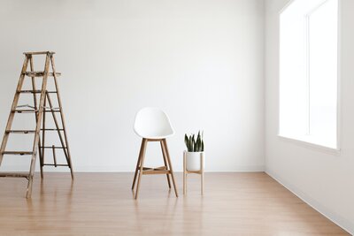 Ladder next to a chair and a plant