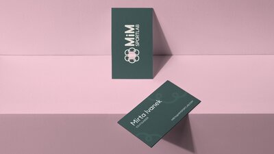 Mocup of a dark green busienss card on a pink background for the brand MiM SportLab
