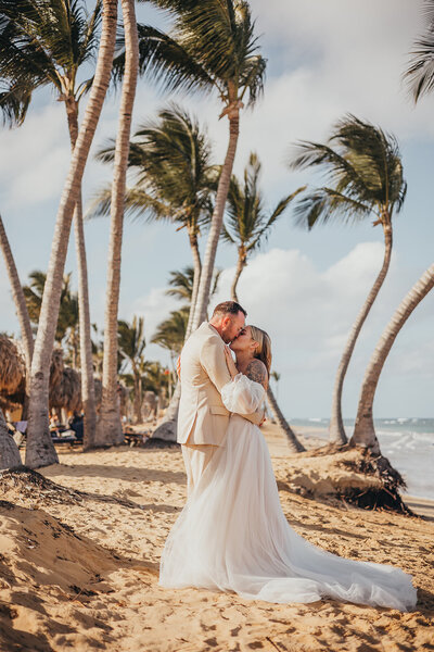 bride and groom embrace on tropical beach