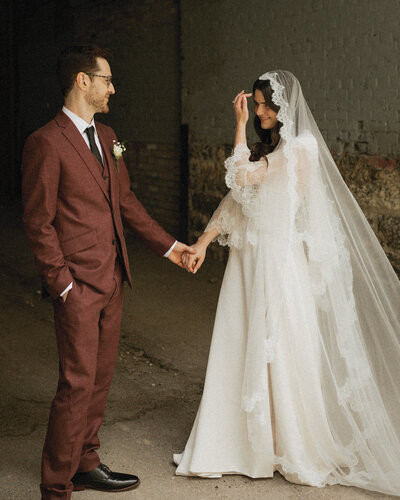 A bride and groom hold hands and gaze into each other’s eyes, capturing a heartfelt and romantic wedding moment.