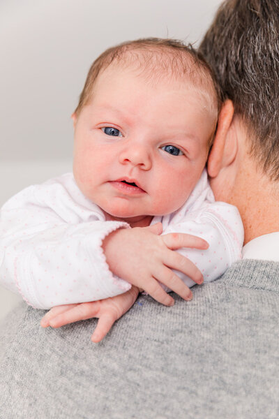 newborn looking above dad shoulder during Buckhead at home photo session | by Laure Photography