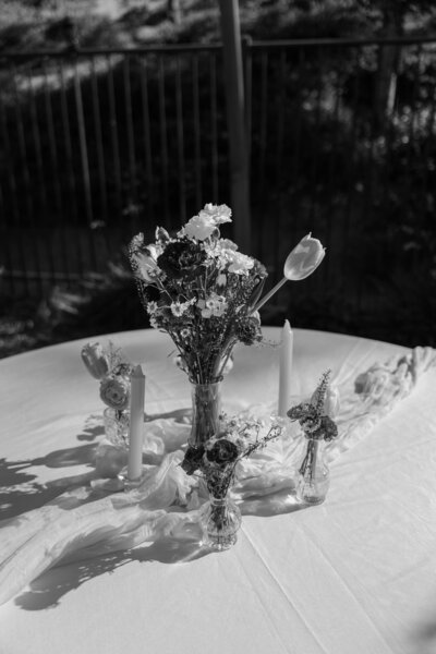 Table floral details at Regan & Yered's backyard wedding, in black and white.