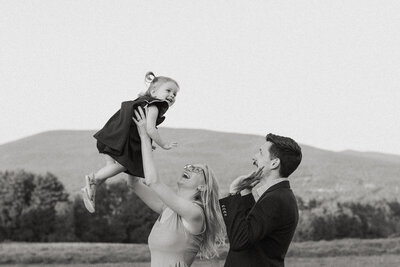 Jess and Corey Combs looking up at their daughter smiling in Manchester, Vermont