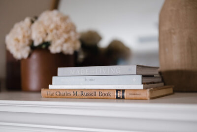 stack of interior design books on mantle