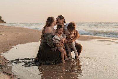 Family sitting together at sunset by Michigan photographers
