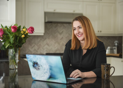 woman in her kitchen on laptop