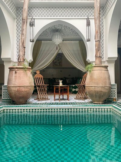 Black and white tiled pool next to an intimate seating area