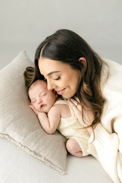 Baby and mum cuddling together and mum smiling