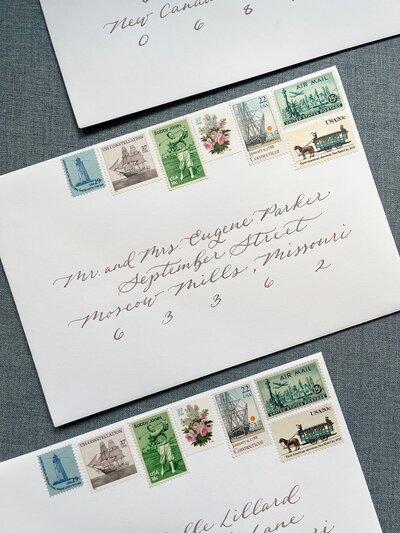 White wedding invitation envelopes with taupe calligraphy and vintage postage stamps for Connecticut wedding
