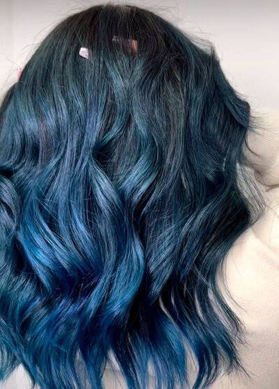 Image of client with dark hair that has been dyed blue.