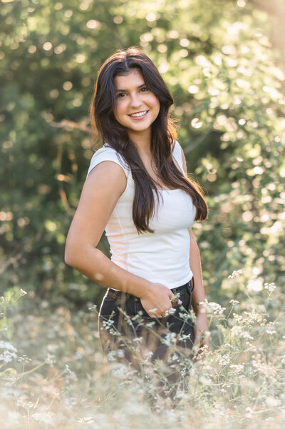 Senior picture of a girl in a navy dress, standing on the steps at Confluence Park in golden light.