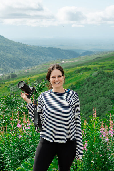 A photographer smiling and holding a camera 