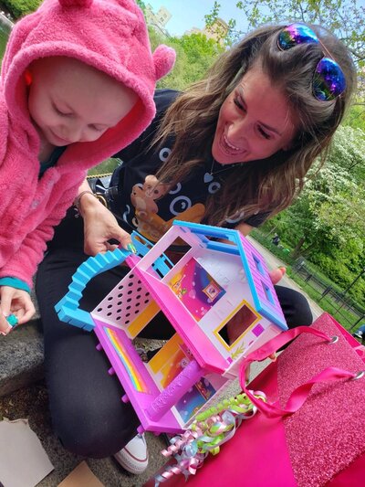 Little girl playing with dollhouse