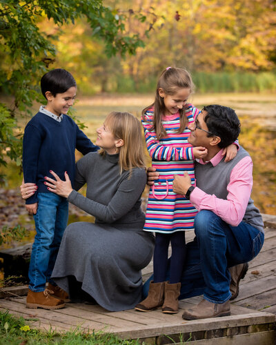 Candid family portrait in fall by pond
