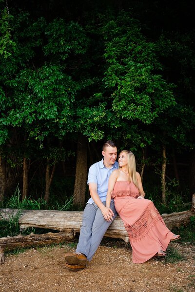 Couple sitting together on a drift log at Long Hunter State Park in Nashville during their elopement photos