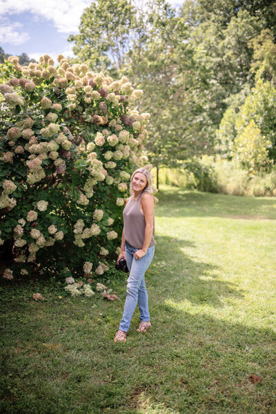Shey Marin posing in front of a flower bush