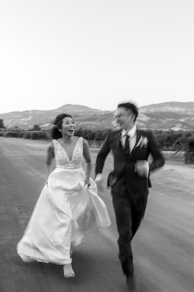 rebecca skidgel photography summer wedding photographer trentadue winery bride groom holding hands running laughing