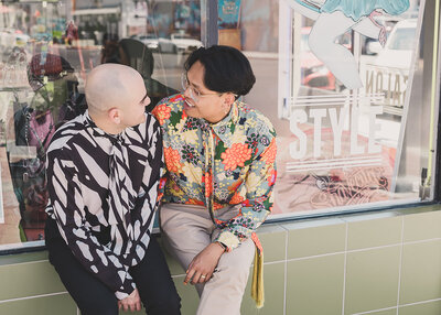 LGBTQ+ couple share a moment outside tattoo parlor after elopement