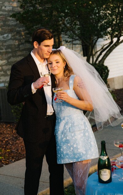 A bride and groom walk down the grand staircase of a French chateau hand in hand.