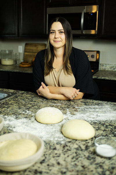 In home sourdough baker shaping dough in kitchen