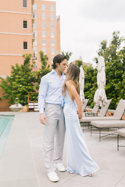 Man and woman kissing in an engagement photo