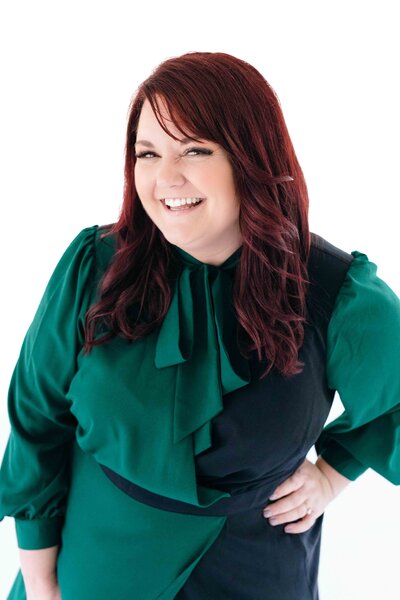 Anna Delores Photography founder, Emily smiles in green and navy dress