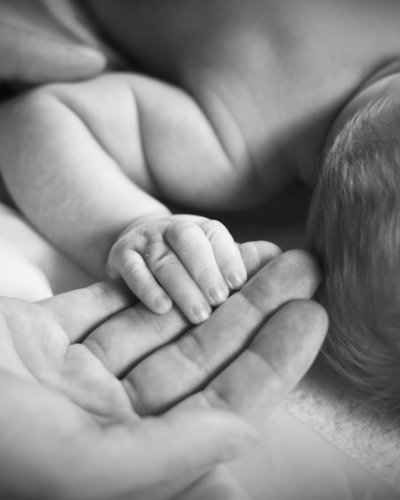 baby and father holding hands black and white