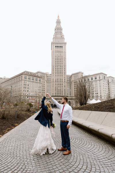 Groom spinning bride in front of Public Square in Cleveland.