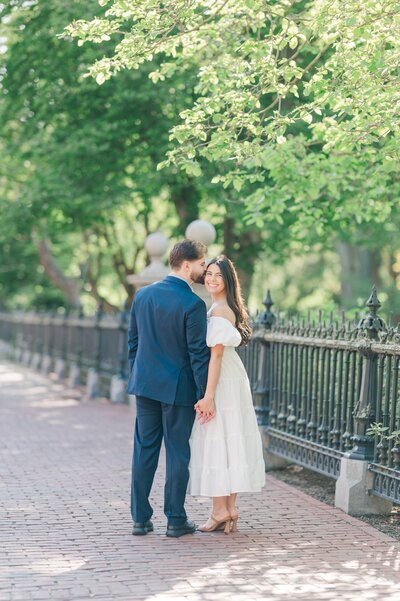 A man and woman kiss at Boston Public Garden. 