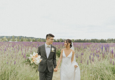 couple holding hands in lupine field