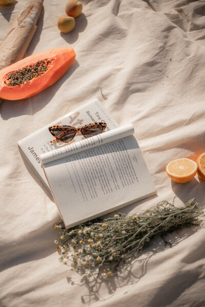 Book, sunglasses, and fruit at the beach