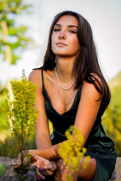 Senior looking at the camera crouching down | Senior Portraits
