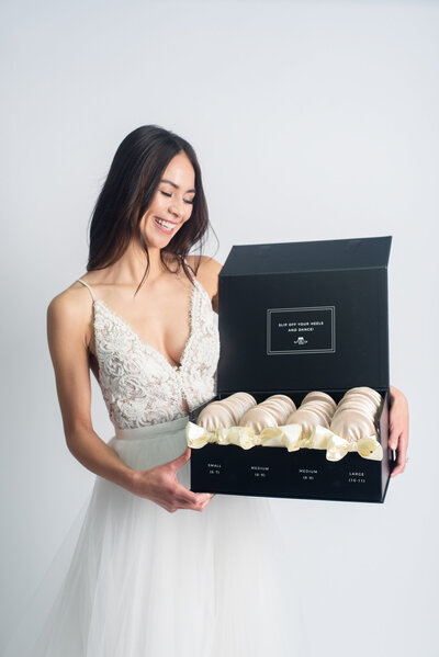 Bride holding box of foldable ballet slippers from Rescue Flats, adorable foldable ballet flats based in Edmonton. Featured on the Brontë Bride Vendor Guide.