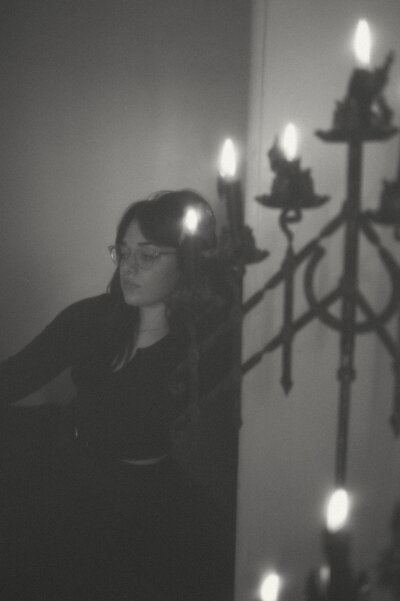 Photographer sitting on stairs with candles in frame