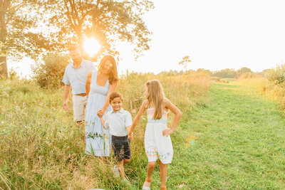 Family of three standing in front of a Christmas tree at sunset