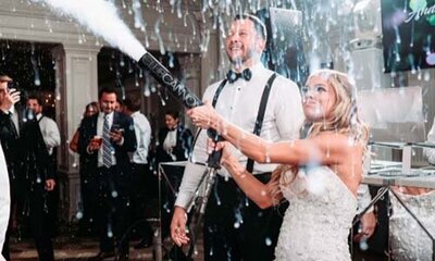 Bride and groom blasting a CO2 cannon on the dance floor in a dramatic wedding party moment