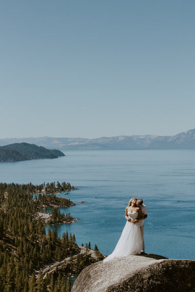 Bride and groom walking along a river within the mountains after their elopmenet