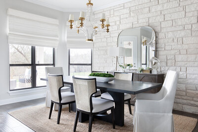 Dining room with white brick walls and chandelier