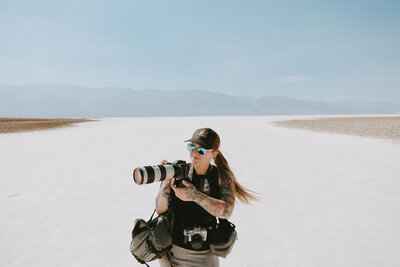 Death Valley elopement photographer standing with her camera at Badwater Basin in Death Valley National Park Rock & Wander Photo Co