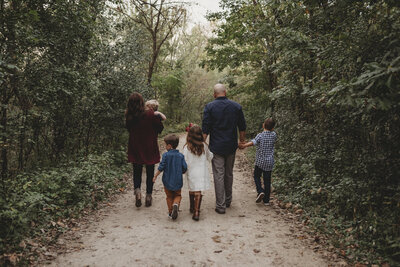 Family walking away from the camera and holding hands