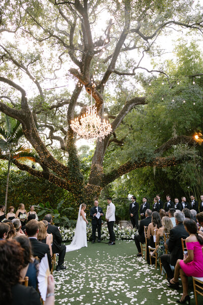 Close up view of delicate wedding dress skirt, wedding bouquet, and heels